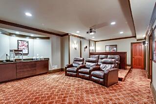 entertaining room for a private residence with leather chairs and red movie theater carpet