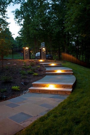 curved flagstone patio illuminated by Trex outdoor lighting  fixtures