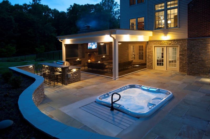 curved flagstone patio, recessed hot tub, and Phantom retractable screened potio at night Clifton, VA (1)