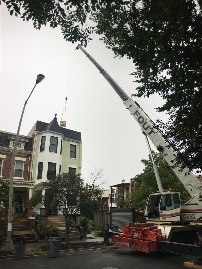 crane rental closing a street in Washington, DC to move supplies from the ground to the roof.