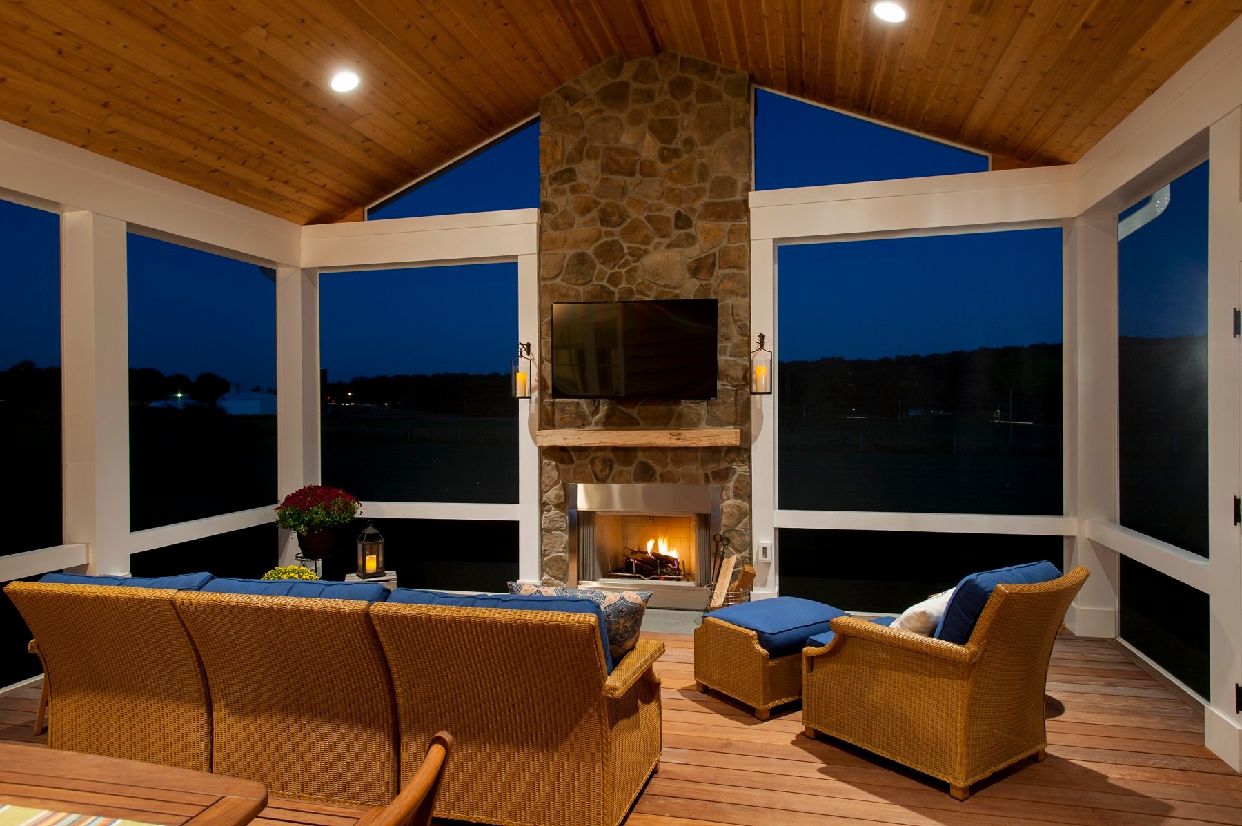 low-voltage lighting in a screened porch with a fireplace at night