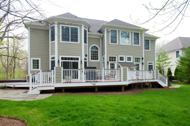 wide angle of flagstone patio and a large elevated deck with white pvc trim