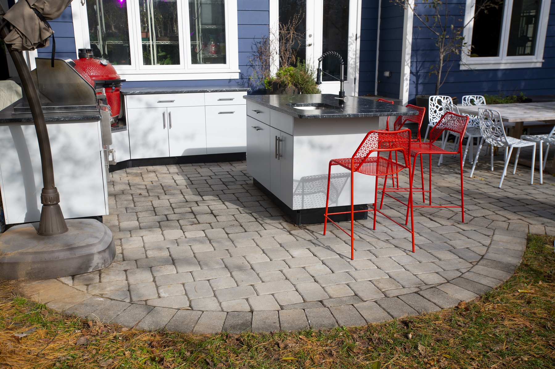 white outdoor kitchen cabinetry with bright orange chairs in falls church, virginia