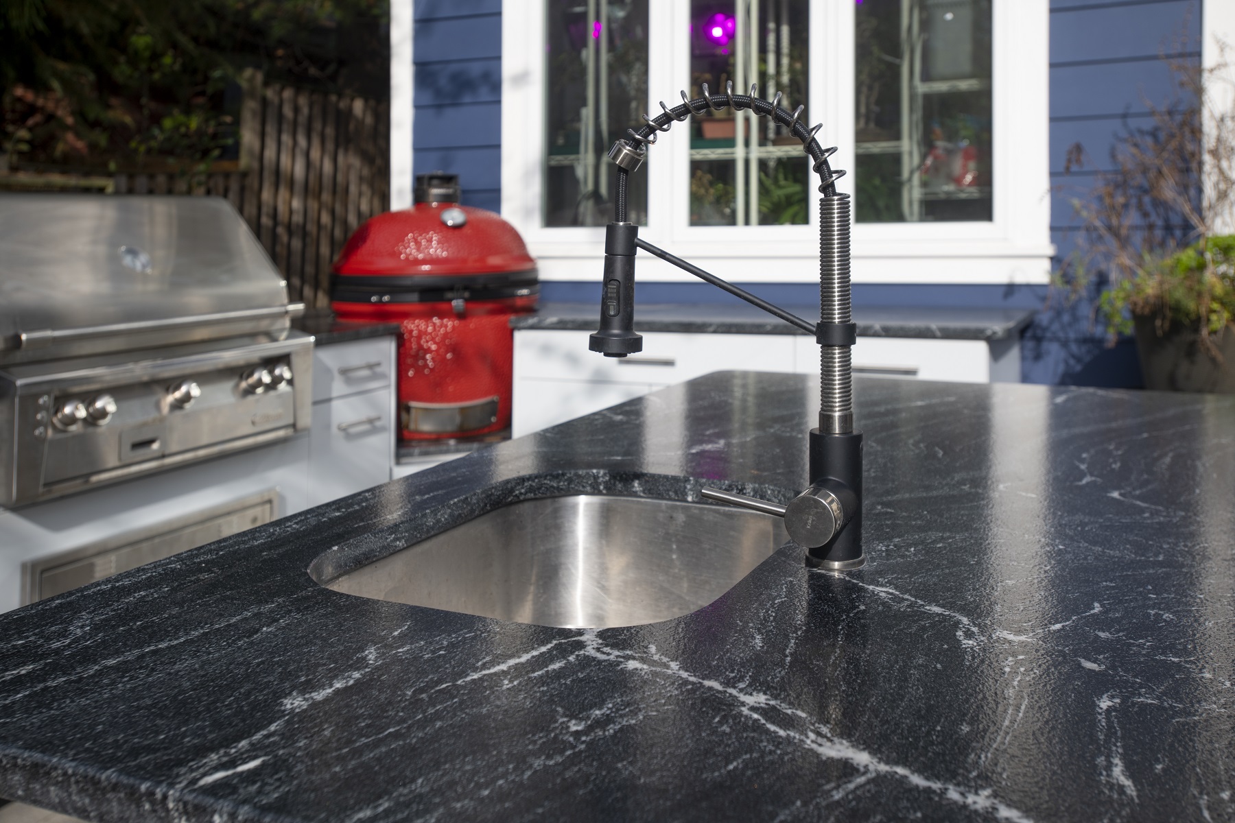 stainless sink for an outdoor kitchen with red green egg smoke and stainless steel grill in the background